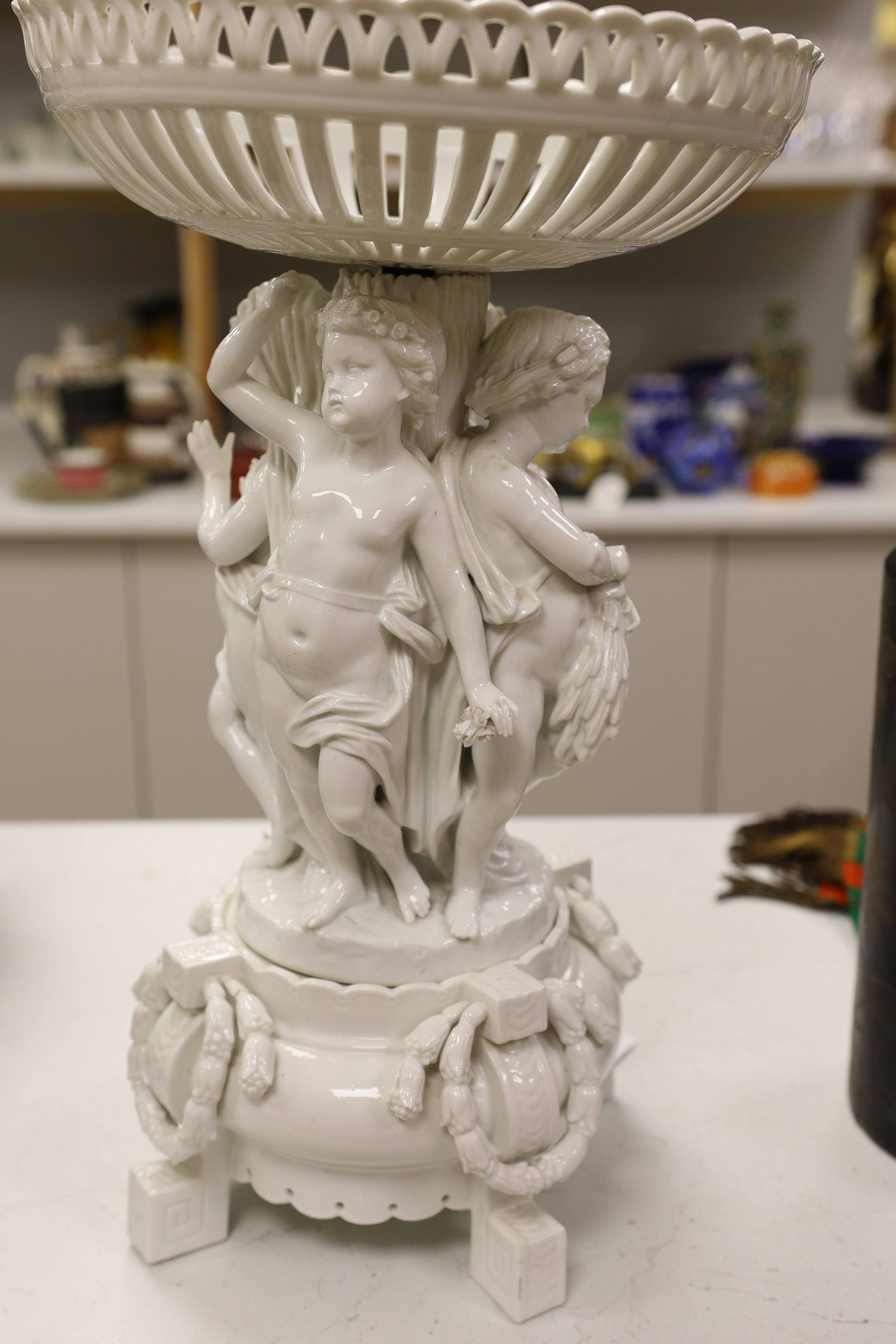 A large Continental white glazed porcelain centrepiece, the stem modelled with with figures emblematic of the four seasons, approx 53cm tall